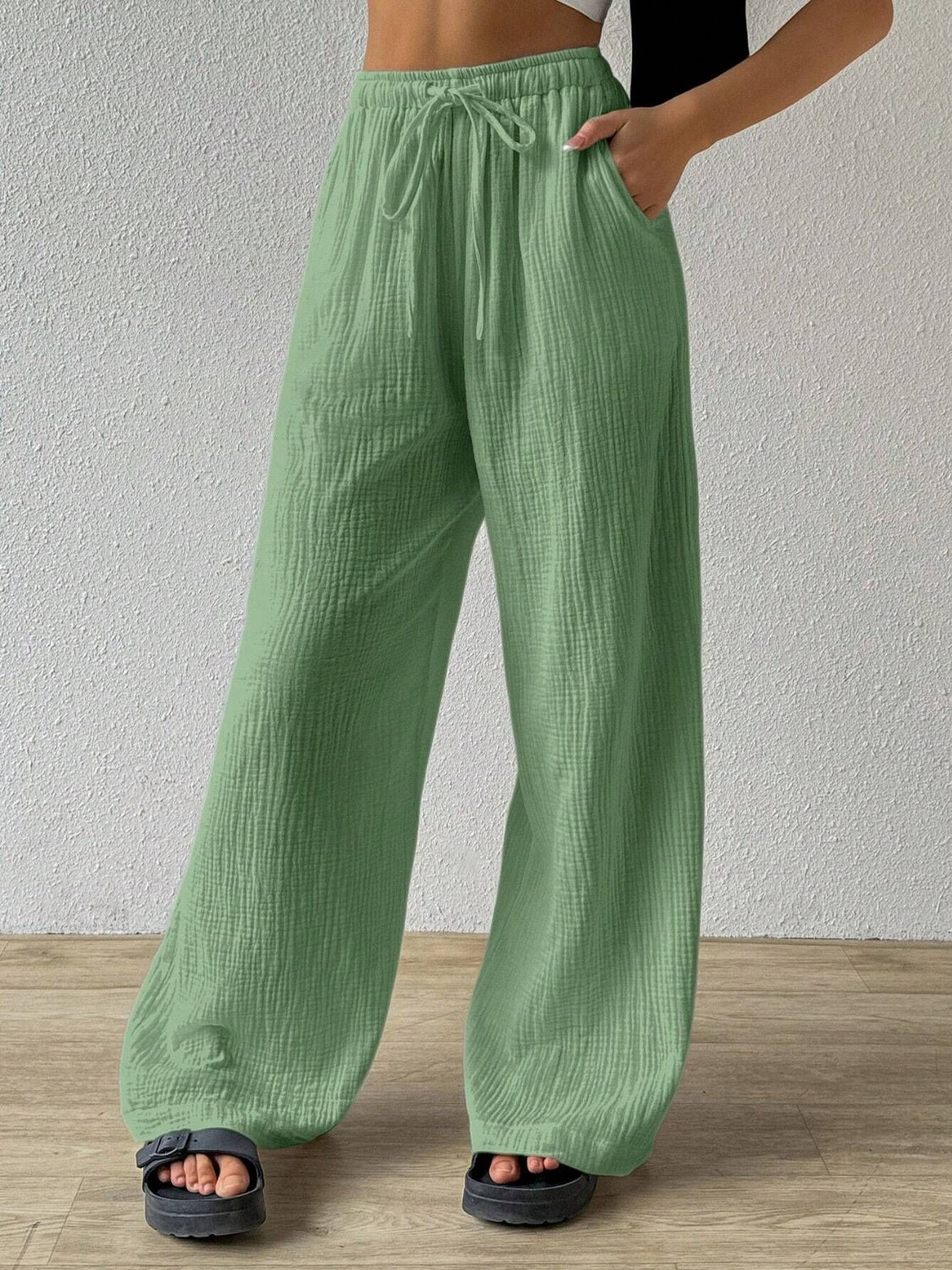 Expertly crafted sage pants for style and comfort, our Drawstring Wide Leg Pants are the perfect addition to any wardrobe. With a versatile drawstring waist and wide leg design, these pants offer maximum ease of movement without compromising on fashion. Elevate your look with these must-have pants.