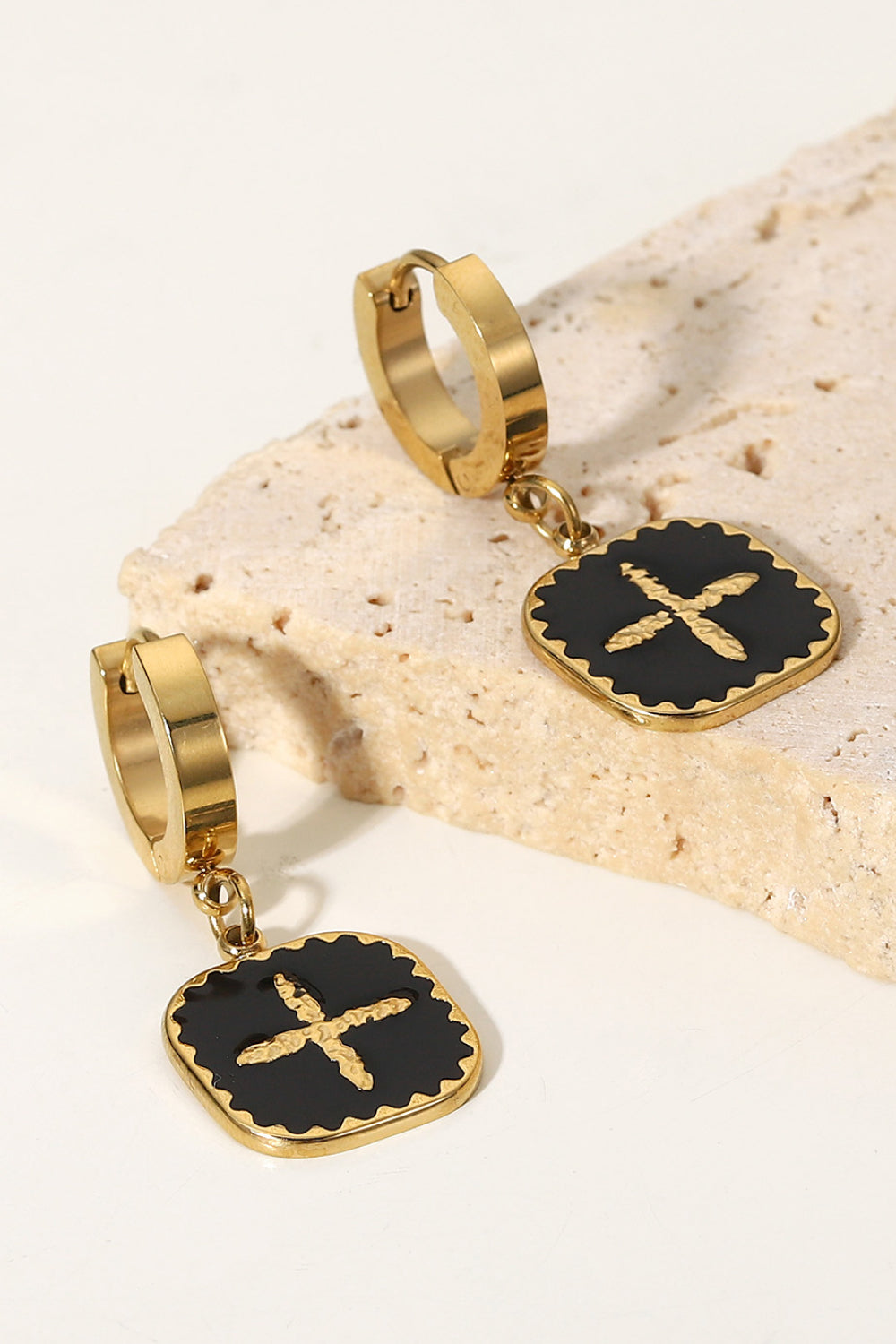 Make a bold statement and elevate any outfit with our Cross Square Drop Earrings. These stunning earrings feature a unique square drop design and sleek cross detail in black and gold. Add a touch of elegance and make a lasting impression with these eye-catching earrings.