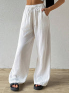 Our white-colored drawstring wide leg pants are perfect for any occasion. The drawstring waist allows for a customizable fit, while the wide leg design provides freedom of movement. Made with high-quality materials, these pants are a must-have in your wardrobe.