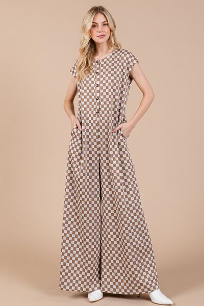 Embrace your adventurous spirit with our Checkered Half Button Cap Sleeve Jumpsuit! This daring and stylish piece features a bold checkered print, chic cap sleeves, and a half button design. Perfect for those who love to make a statement and stand out from the crowd. Take a risk and unleash your unique style with this jumpsuit!