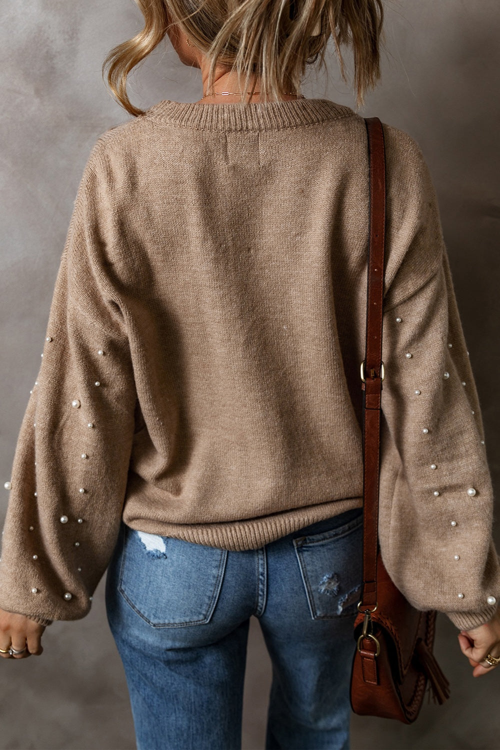 Elevate your style with our Cruisin Essentials Sweater! Adorned with elegant pearls on the round neck and sleeves, this cozy sweater adds sophistication to any look. Dare to be bold and stand out from the crowd with this statement piece.