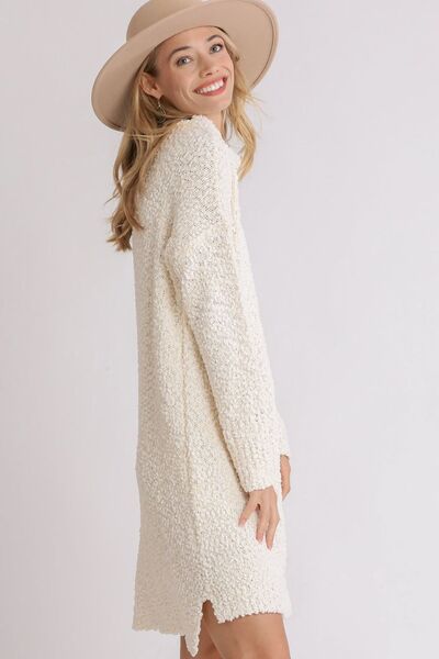 Elevate your wardrobe with Umgee's High Low Boucle Sweater Dress. Luxurious full-size fit, long sleeves, and unique bounce fabric add texture and sophistication. Keep warm and stylish in this exclusive piece, available in plus size for a flattering fit. Indulge in elegance with every wear.