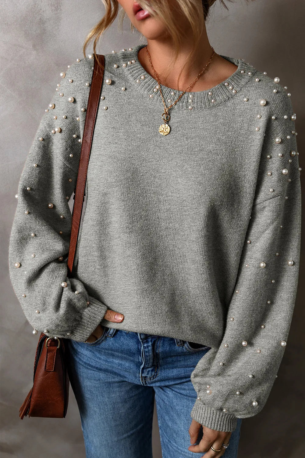 Elevate your style with our Cruisin Essentials Sweater! Adorned with elegant pearls on the round neck and sleeves, this cozy sweater adds sophistication to any look. Dare to be bold and stand out from the crowd with this statement piece.