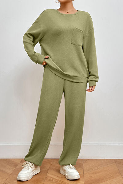 Trendsi Trends Pocketed Round Neck Top and Pants Lounge Set - the perfect escape from the chaos of the holiday season. Unwind in peaceful bliss with your favorite tunes and a soothing soak in the tub. This loungewear set is every woman's dream adventure. Cozy up by the fire with a cup of matcha tea and our matcha green lounge set.